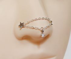 a close up view of a nose with a chain and star charm attached to it