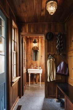 a bathroom with wood paneling and a chandelier hanging from the ceiling above it