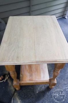 a wooden table sitting on top of a floor next to a chair and window sill