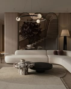 a living room filled with white furniture and a tree on the wall above it's coffee table