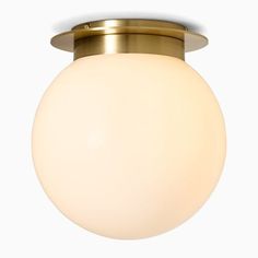 an overhead view of a ceiling light with a white ball on the top and gold trim