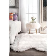 a white rug is on the floor near a bed