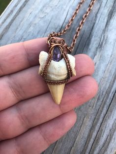 Otodus Fossil Shark Tooth Wire Wrapped Pendant with Natural Amethyst in Antiqued Copper with Chain A 65 million year old fossil shark tooth from the extinct shark Otodus is wire wrapped in antiqued copper with a beautiful natural purple amethyst. Shark tooth pendants and necklaces are said to offer protection from evil. And keep anyone who swims in the water safe Comes with an 18inch antiqued copper chain If you have any questions please feel free to message me If outside of the US please contac Wire Wrapped Bones, Handmade Arrowhead Jewelry Gift, Soldered Purple Pendant Jewelry, Purple Soldered Pendant Jewelry, Adjustable Electroformed Purple Jewelry, Adjustable Purple Electroformed Jewelry, Purple Amethyst Jewelry With Soldered Details, Wire Wrap Shark Tooth, Shark Tooth Jewelry