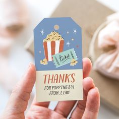 a person holding up a thank card with popcorn on it