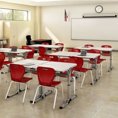 an empty classroom with desks and red chairs