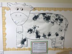 a cow is shown on the wall in front of a sign that reads, evidence of education