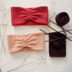 three different types of headbands on top of a table next to some flowers