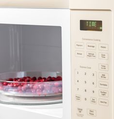 a white microwave oven with food in it's door and timer on the side