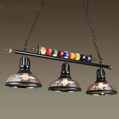 three lights hanging from the ceiling with billiards on it's end and eight ball holders in front