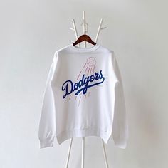 90s Los Angeles Dodgers MLB sweatshirt/ L * PLEASE READ BEFORE PURCHASE * PLEASE consider the PHOTOS before making the decision * The images may DIFFER in appearance from the actual product because we took pictures under daylight.  * PLEASE send your PHONE NUMBER after your purchase for the shipping company to contact you X No returns X No refund Condition : 9/10 More details : look at the pictures  Brand : Tultex Size : L Pit to pit/ Chests : 22.5/45 inches  Length : 26.5 inches  Material : cotton polyester  Color : white * ALL ITEMS are VINTAGE which may show some signs of wear and tear * Due to the different display and different light, the picture may not reflect the actual color of the item * Please, remember that our items are vintage so they may show some signs of wear, tear and yel Throwback Crew Sweatshirt For Sports Season, College Throwback Style Sweatshirt With Screen Print, Throwback Long Sleeve Letter Print Sweatshirt, White Long Sleeve Throwback Sweatshirt, 90s Oversized Sweatshirt With Letter Print, Oversized 90s Letter Print Sweatshirt, Throwback Hoodie With Letter Print And Crew Neck, Throwback Crew Neck Hoodie With Letter Print, White Throwback Sweatshirt With Letter Print