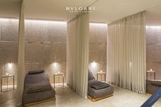 a spa room with stone walls and white drapes