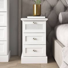 a white nightstand with a potted plant on top