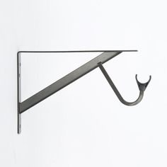 a pair of scissors hanging from the side of a metal hook on a white wall