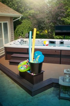 an outdoor hot tub with toys and inflatables on the deck next to it