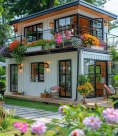 a white house with lots of flowers on the balcony