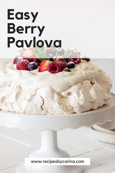 an easy berry pavlova on a white cake stand