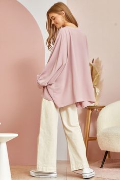 This blouse is out to prove that comfy and chic can coexist in perfect harmony. Its flowy, dolman cut gives you room to breathe while still maintaining a flattering drape. 3/4 sleeves keep it seasonal, transitioning effortlessly from summer to fall. A plunging V-neckline shows just enough skin to be subtly seductive, but the blush pink hue is as sweet and charming as an English rose garden. In short, this top lets you make a stylish statement without having to sacrifice one ounce of comfort. It’ Chic Oversized Long Sleeve Blouse, Chic Solid Color Blouse For Loungewear, Chic Solid Blouse For Loungewear, Chic Blouse For Loungewear, Oversized Blouse For Day Out, Flowy Blouse For Spring Loungewear, Oversized Lantern Sleeve Blouse For Spring, Chic Oversized Solid Color Blouse, Chic Oversized Solid Blouse