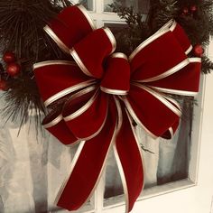 a red bow hanging on the side of a door