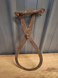 an old pair of scissors sitting on top of a wooden table next to a metal wall