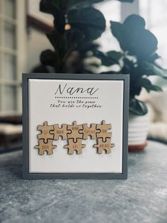 three wooden puzzle pieces sitting on top of a table next to a potted plant