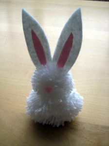 a white bunny rabbit hat sitting on top of a wooden table