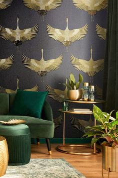 a living room with green velvet furniture and gold wallpaper, including a peacock motif