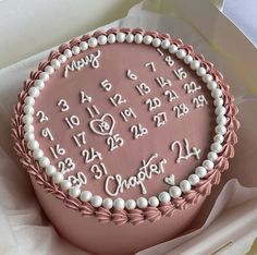 a pink cake with white frosting and numbers on it