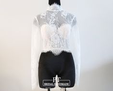 a mannequin wearing a white lace top and black shorts