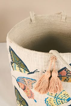 a close up of a bag with tassels and butterflies on the front side