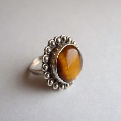 Charming silver ring with tiger's eye in cabochon cut. Flower shaped 92.5 silver ring from India. Measures: OL: 56 N 16 US: 7.5 Inside diameter: 17.75 mm Shipping: Certified Post Office Mail with track number Thanks for your visit! Sterling Silver Brown Rings With Polished Finish, Sterling Silver Rings With Brown Polished Finish, Brown Sterling Silver Rings With Polished Finish, Brown Sterling Silver Cabochon Ring, Brown Sterling Silver Ring With Cabochon, Brown Gemstone Ring In Sterling Silver, Brown Gemstone Rings In Sterling Silver, Brown Gemstone Sterling Silver Rings, Tiger Eye Jewelry