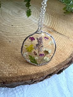 Handmade Epoxy resin necklace with real dried flowers. Made in the UK. Perfect and unusual gift idea. Comes beautifully presented in a gift box. Pendant material - alloy, hypoallergenic. Chain material:  sterling silver, silver plated, lightweight.  Stay close to nature with this necklace. Perfect happy summer necklace with bright colours flowers. Perfect anniversary, birthday or leaving gift.  Clover flower The meaning and symbolism of clover flowers are closely associated with good fortune and Keepsake Jewelry Round Pendant With Natural Inclusions, Keepsake Round Pendant With Natural Inclusions, Unique Flower-shaped Birth Flower Necklaces, Bohemian Silver Necklaces With Pressed Flowers, Handmade Clear Keepsake Jewelry, Handmade Round Pendant Necklace For Keepsake, White Necklaces With Pressed Flowers For Mom, Unique Birth Flower Necklace, Handmade Flower Pendant Keepsake Jewelry