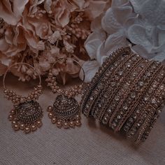 several different types of jewelry sitting next to flowers