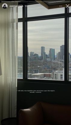 a living room filled with furniture and large windows overlooking the cityscape in the distance