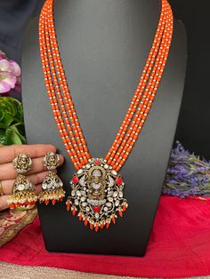 Goddess Lakshmi Pendant Coral Beads Haram with Earrings/Victorian Mehandhi Finish Orange Coral AD Haram/34.5 Inches Long/Indian Jewelry DETAILS: Includes:  One Long Haram and Two Earrings. Necklace: 22.8inches.Adjustable length. Chain Closure. Weighs 2.15oz (62g).  Earrings: 2.1 inch(es) long.  Width : one inches Earring set  weighs 1.005 Oz ( 29 g). Earring backs  Screw to on/off. Material: Imitation, Victorian  mehndhi Polish pearls,  Finish: Victorian polish Long Haram with Earrings.  NOTE: I Luxury Red Temple Necklace For Festivals, Traditional Orange Beads For Festive Occasions, Orange Jewelry For Diwali Puja, Traditional Orange Jewelry For Diwali, Traditional Orange Jewelry With Silver Beads, Orange Festive Jewelry For Celebration, Festive Orange Jewelry For Celebration, Orange Festive Celebration Jewelry, Traditional Orange Jewelry For Celebration