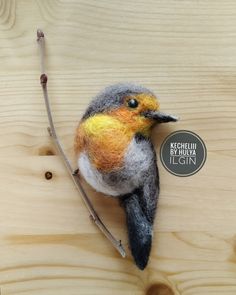 a needled bird sitting on top of a wooden table