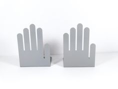 two white hand shaped bookends sitting on top of each other