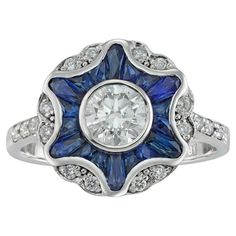 A diamond and sapphire cluster ring, the round brilliant-cut diamond weighing 0.70 carats accompanied by IGL certificate stating to be of H colour and VS2 clarity surrounded by calibre-cut sapphires forming a star, embellished with twelve small round brilliant-cut diamonds set in pairs between six rays, the small diamonds estimated to weigh ¼ of a carat in total, all set in white gold mount with openwork gallery and diamond-set shoulders, finger size N ½ , hallmarked 18ct gold, London, bearing the Bentley & Skinner sponsor mark, measuring approximately 2x1.4cm in diameter, gross weight 3.8 grams. This ring is in excellent condition. A sparkling and colourful ring. This piece features a dazzling central diamond surrounded by a frame of vivid blue sapphires set into the shape of a star and s Luxury Sapphire Diamond Cluster Ring, Sapphire Cluster Ring, Ornate Ring, Geometric Star, Diamond Brooch, Beautiful Engagement Rings, Modern Ring, Sapphire Stone, Diamond Cluster Ring