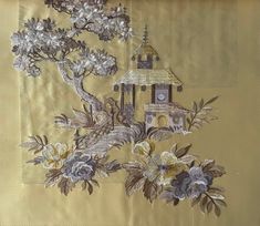 an embroidered wall hanging with flowers and a clock tower on the top, in front of a gold background