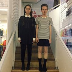 two people standing on the stairs in front of a sign