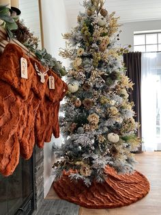 a decorated christmas tree in the corner of a living room with stockings hanging from it