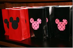 three black and red bags with minnie mouse ears on them are sitting on a shelf