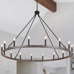 a large chandelier with candles hanging from it's center ring in a kitchen