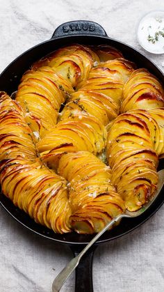 a cast iron skillet filled with baked potatoes