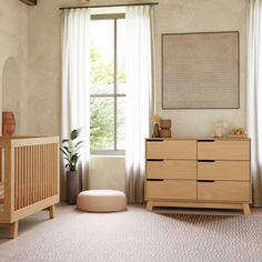 a baby's room with two cribs, a dresser and a large window