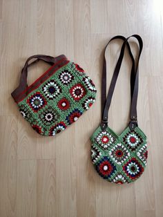 two purses are laying on the floor next to each other, one is green and the other is red