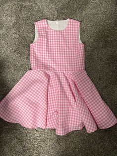 Beautiful  Barbie inspired pink gingham checked twirl dress..  The gingham fabric is Robert Kaufman  cotton.  The sleeveless dress has a fully lined bodice.  The back closes with kam Plastic  snaps.  The dress has a full circle twirl for that little dancer.    I would be happy to make this dress in other colors or fabric.  available in sizes 12 months to size 8  Measurements will be in the photo section Cute Ruffled Plaid Dress For Spring, Fitted Gingham Dress For Garden Party, A-line Plaid Dress For Picnic, Plaid Ruffled Dresses For Garden Party, Fitted Gingham Plaid Dress With Ruffles, Spring Plaid A-line Dresses, Gingham Dresses With Ruffles For Picnic, Spring Gingham A-line Dress, Gingham Dress With Ruffles For Picnic