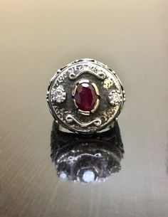 DeKara Designs ClearanceMetal- Sterling Silver, .925, 14K Yellow Gold.Stones- 1 Natural Oval Ruby 1.15 Carats, 2 Round Diamonds G-H Color SI2 Clarity, 0.25 Carats.  Size- 8.5.  FREE SIZING!!!! Art Deco Inspired elegantly handmade sterling silver and 14K yellow gold oval ruby and diamond engagement ring.  The center stone is set in a unique type of prong setting that is made in 14K yellow gold.  The ruby has one fiery round diamond in the same type of unique prong setting on each side.  The ring Luxury Handmade Ruby Ring, Antique Ruby Rings With Polished Finish, Heirloom One-of-a-kind Jewelry For Anniversary, Unique Oval Jewelry For Ceremonial Occasions, Luxury Silver Ruby Ring With Polished Finish, Unique Ruby Ring With Diamond, Luxury Hallmarked Silver Ruby Ring, Luxury Diamond Rings For Ceremonial Occasions, Ceremonial Heirloom Oval Ruby Ring