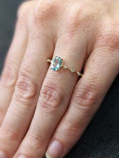 a woman's hand with a ring on it and a blue stone in the middle