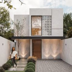 a person walking in front of a modern house