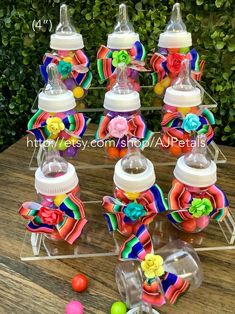 several baby bottles with colorful ribbons and bows on them sitting on top of a wooden table